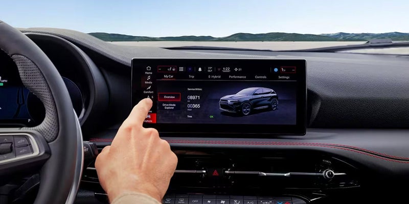 A hand touches a Dodge Hornet infotainment screen