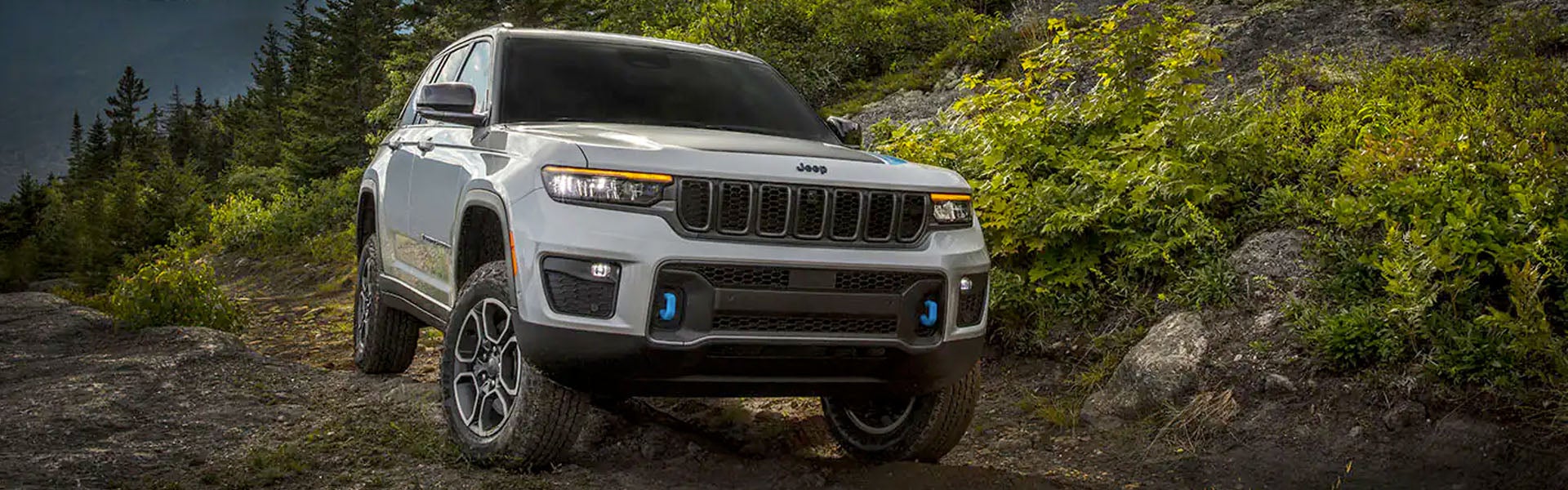 Jeep Grand Cherokee 4xe off-roading on rocky forest trail