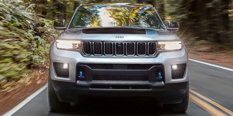 Jeep Grand Cherokee 4xe SUV driving through forest road