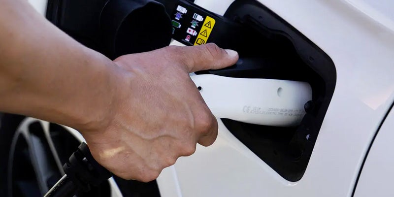 Hand plugging in Jeep Grand Cherokee 4xe electric vehicle charger