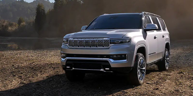 Jeep Grand Wagoneer SUV driving through off road in forest