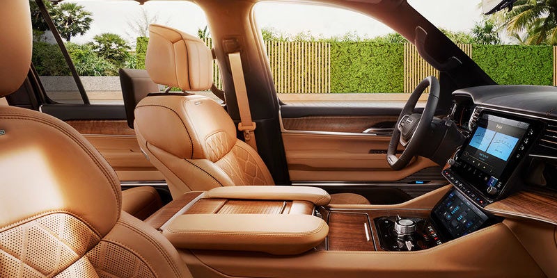 Jeep Grand Wagoneer Luxurious tan leather SUV interior with touchscreen display.