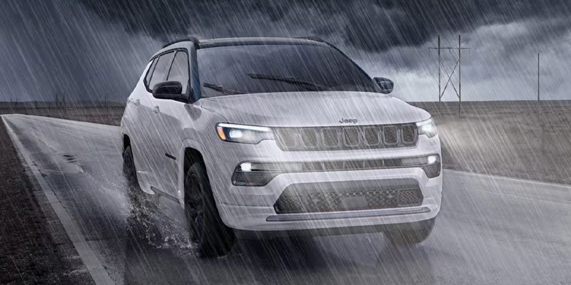 Jeep Compass SUV driving in heavy rain