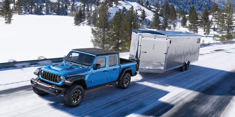 Jeep Gladiator towing trailer in snowy mountains