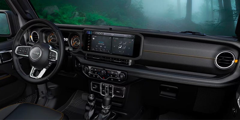 Jeep Wrangler 4xe dashboard with touchscreen and controls inside foggy forest