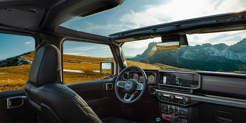 Jeep Wrangler 4xe interior with panoramic roof showing mountain landscape outside